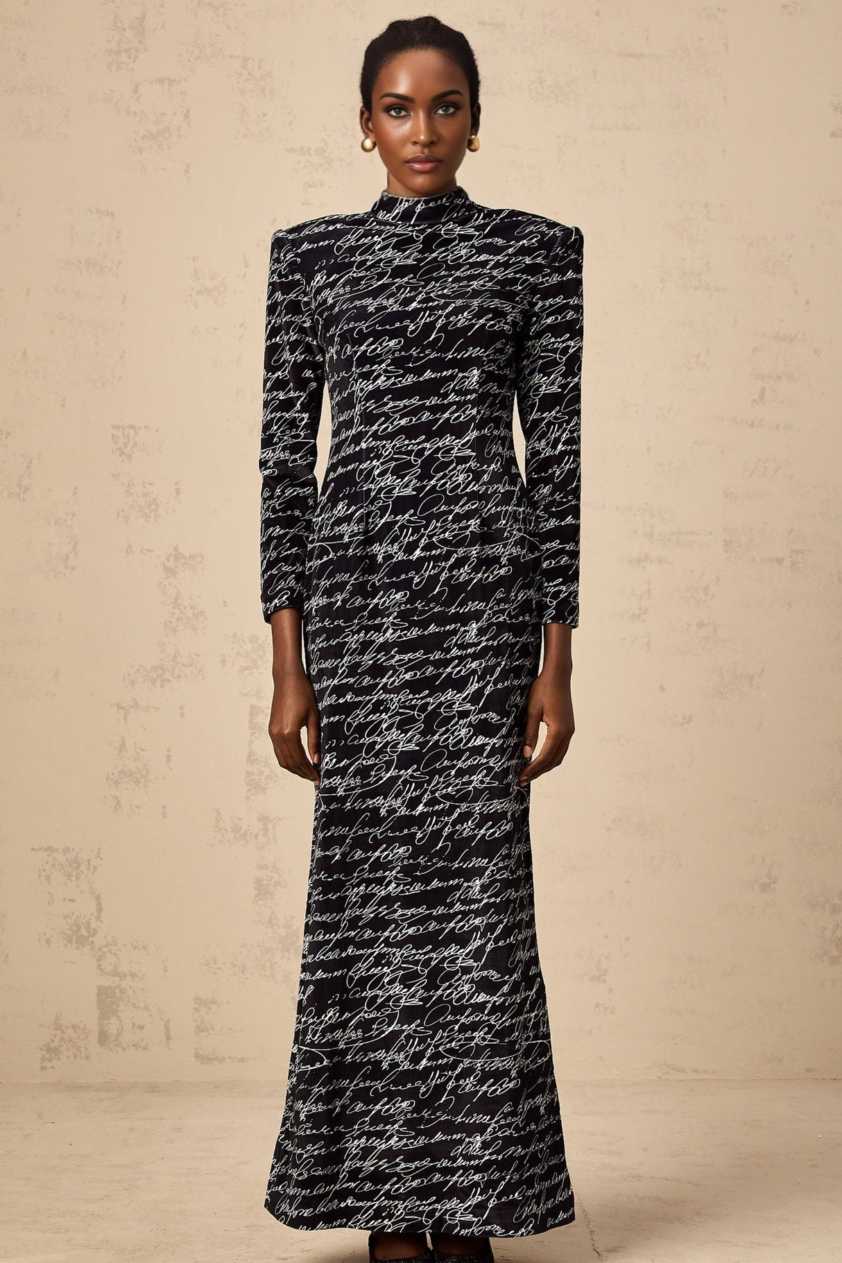 A long black velvet maxi dress with jade green lettering printed on it