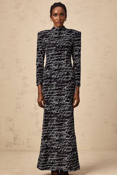 A long black velvet maxi dress with jade green lettering printed on it