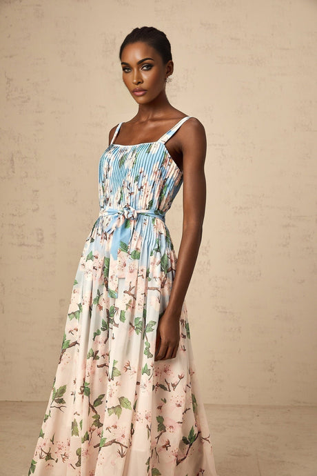 A long blue maxi dress with a floral print pattern and pleated design
