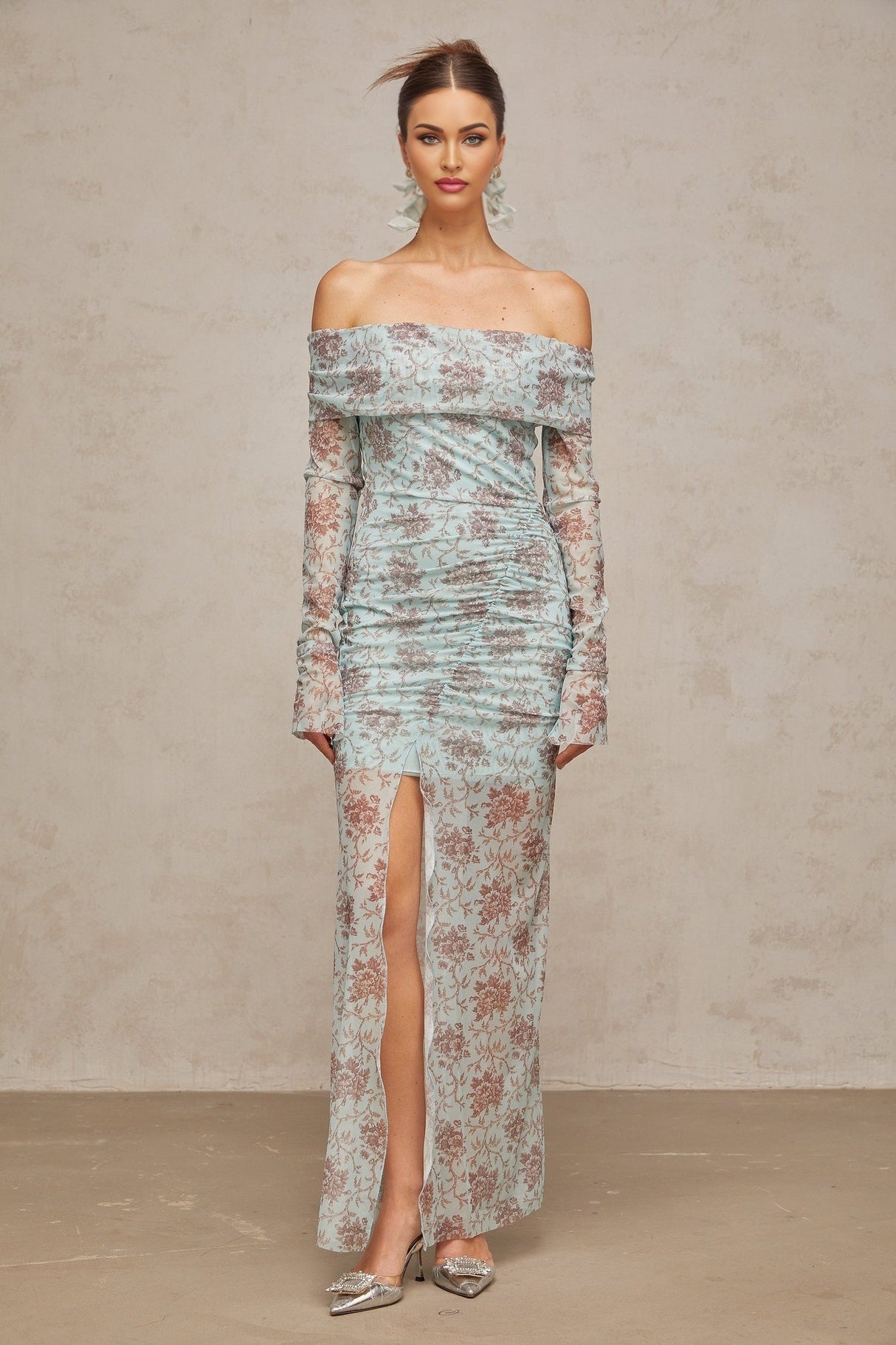 A long blue maxi dress with a floral print pattern and ruched detailing