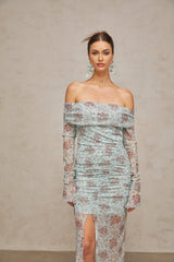 A long blue maxi dress with a floral print pattern and ruched details