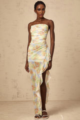 A long blue maxi dress with an asymmetric design featuring a floral print pattern and ruched detailing