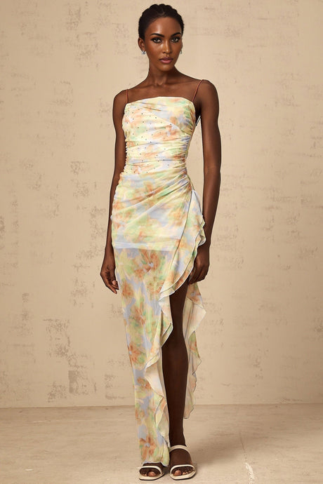 A long blue maxi dress with an asymmetric design featuring a floral print pattern and ruched detailing