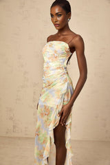 A long blue maxi dress with an asymmetric design featuring a floral print pattern and ruched detailing