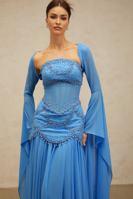 A long blue pleated maxi dress with faux pearl embellishments by Gaelle