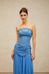 A long blue pleated maxi dress with faux pearl embellishments by Gaelle
