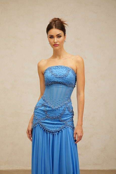 A long blue pleated maxi dress with faux pearl embellishments by Gaelle