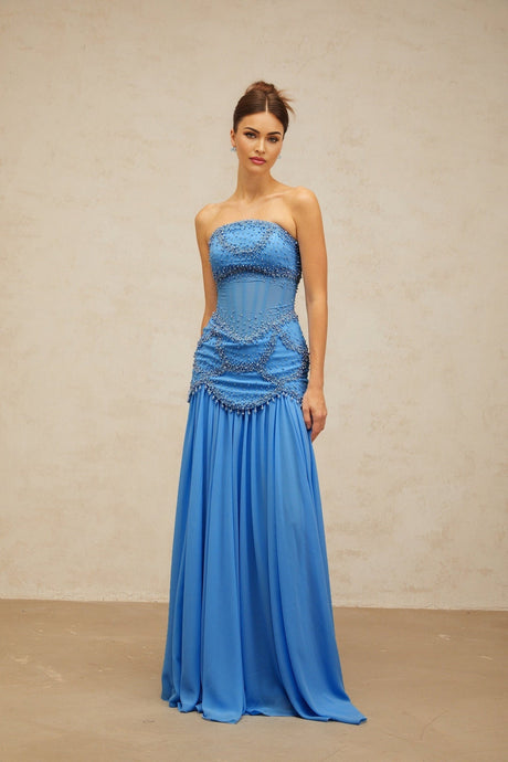 A long blue pleated maxi dress with faux pearl embellishments by Gaelle