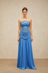 A long blue pleated maxi dress with faux pearl embellishments by Gaelle