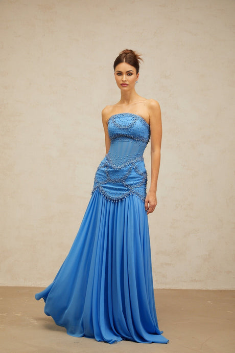 A long blue pleated maxi dress with faux pearl embellishments by Gaelle