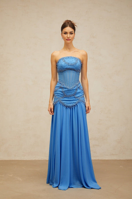 A long blue pleated maxi dress with faux pearl embellishments by Gaelle