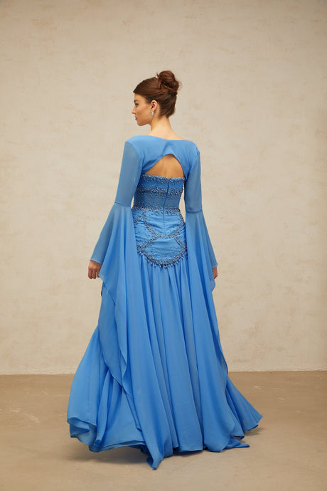 A long blue pleated maxi dress with faux pearl embellishments by Gaelle