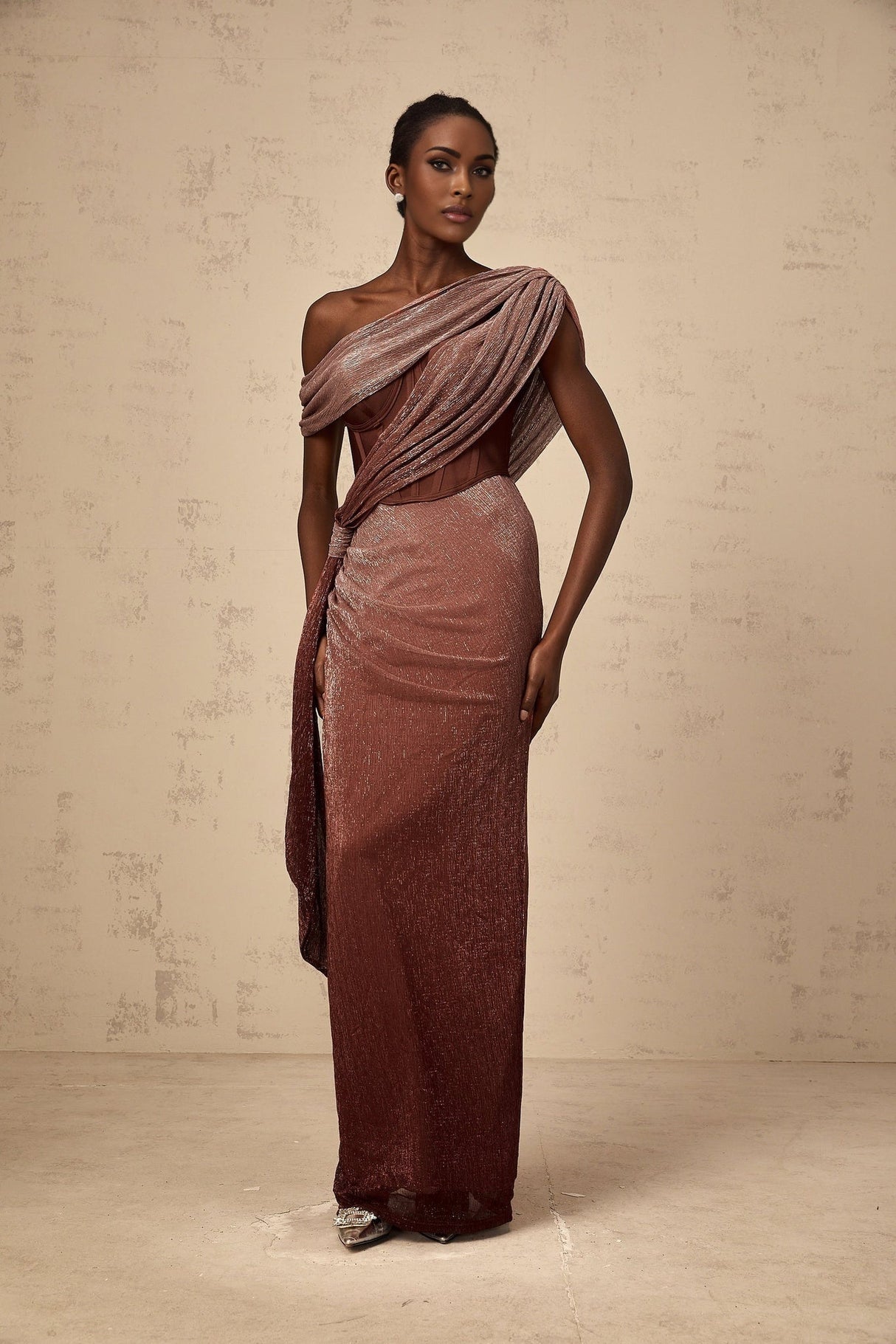 A long brown maxi dress with a corsetstyle top featuring ribbon design details and a flowing skirt