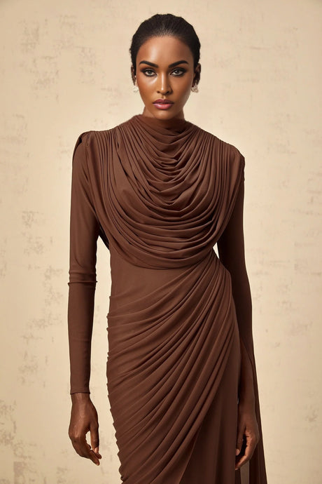 A long brown maxi dress with shirred detailing and draped fabric creating an elegant flowing silhouette