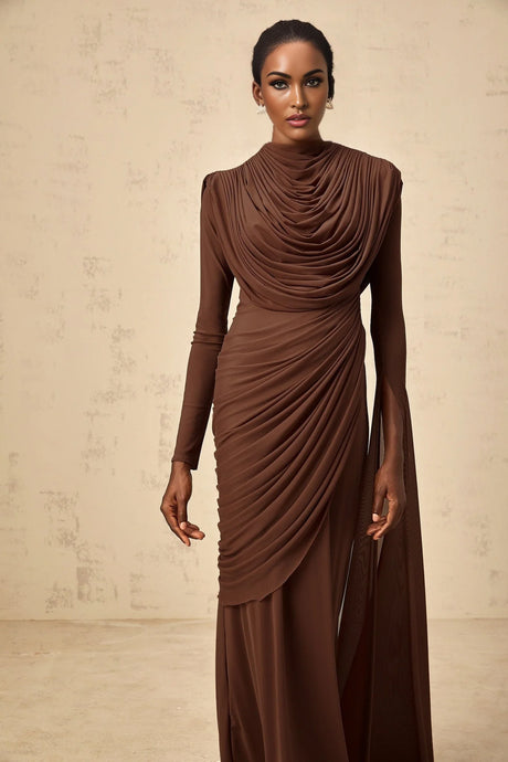 A long brown maxi dress with shirred detailing and draped fabric featuring a flowing silhouette and elegant design