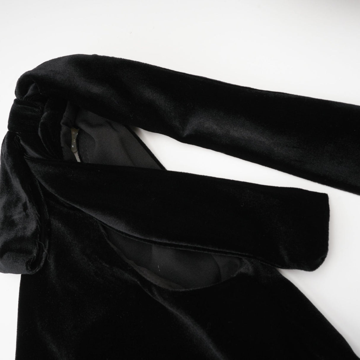 A long dark velvet dress with an open back and embellished details named Audrey shown on a model against a plain background