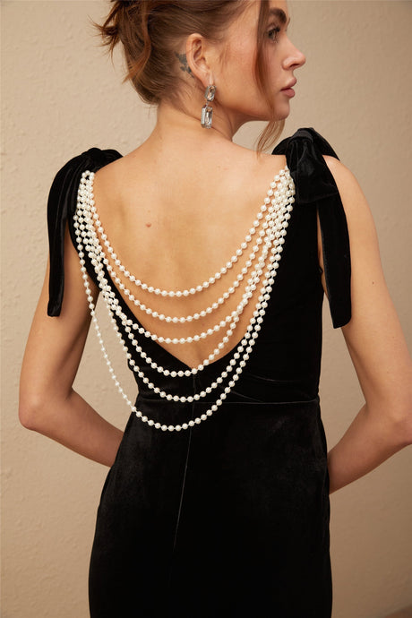 A long dark velvet dress with embellishments and an open back design called the Audrey maxi dress