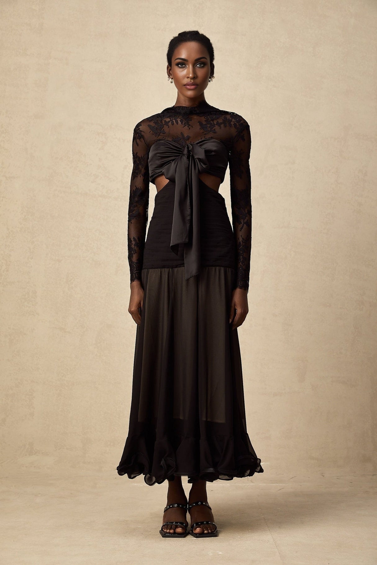 A long elegant maxi dress with floral lace panels featuring a delicate pattern throughout the garment The dress has a flowing silhouette and appears to be made of lightweight fabric suitable for formal or evening wear