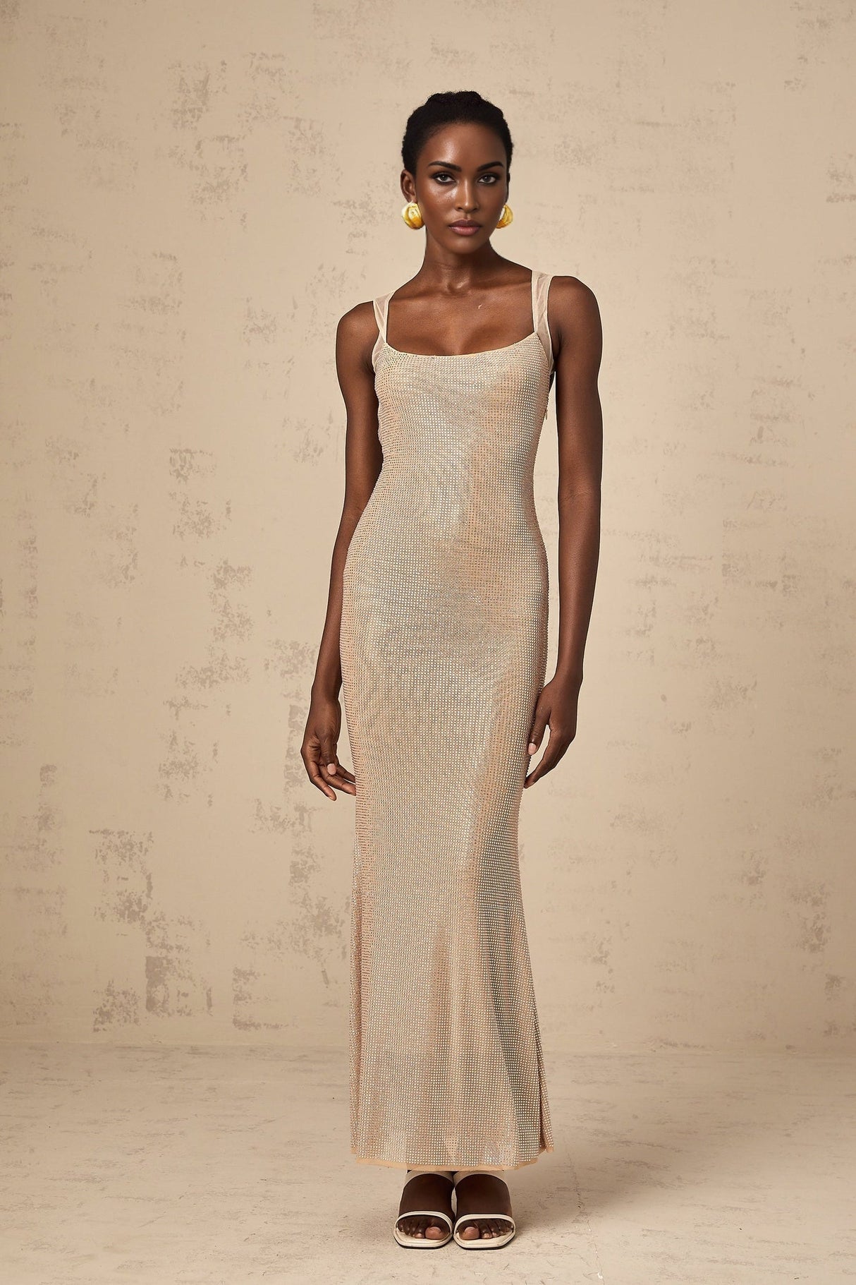A long elegant white maxi dress with crystal embellishments and an open back design