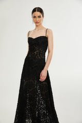 A long floral lace maxi dress in white with delicate floral patterns covering the entire garment featuring long sleeves and a floor length skirt