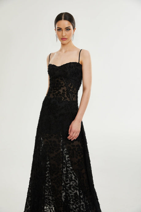 A long floral lace maxi dress in white with delicate floral patterns covering the entire garment featuring long sleeves and a floor length skirt
