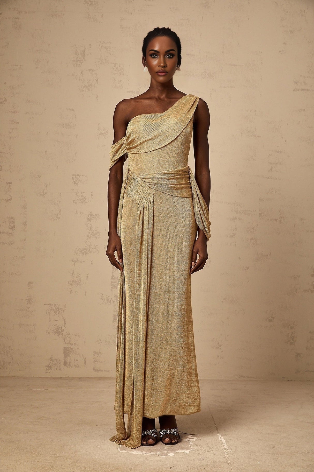 A long flowing golden maxi dress with gathered fabric and ribbon design details