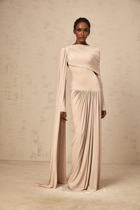 A long flowing maxi dress in neutral tones featuring a draped design with ribbon details