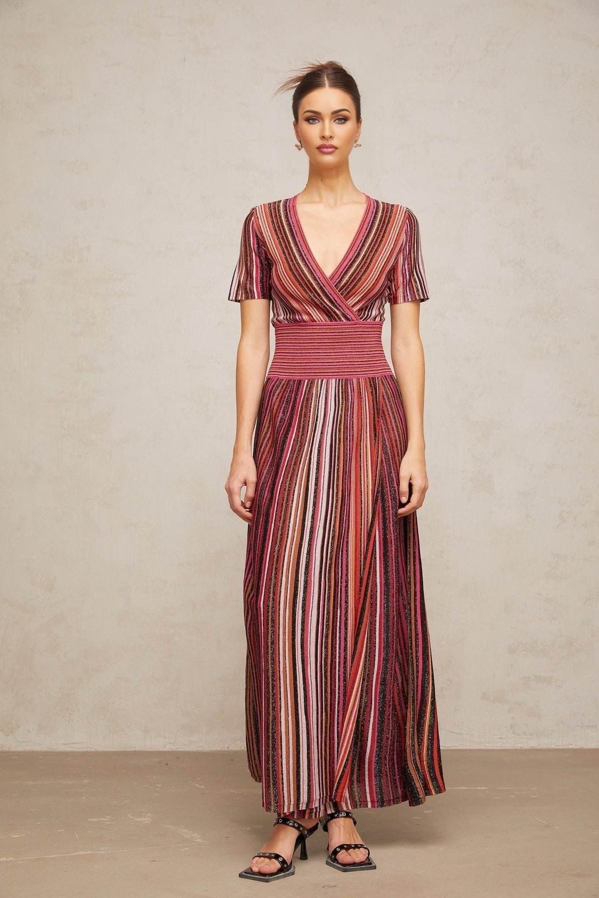 A long flowing maxi dress with a multicolor metallic knit pattern showcasing shimmering threads in various hues
