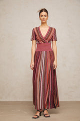 A long flowing maxi dress with a multicolor metallic knit pattern showcasing shimmering threads in various hues