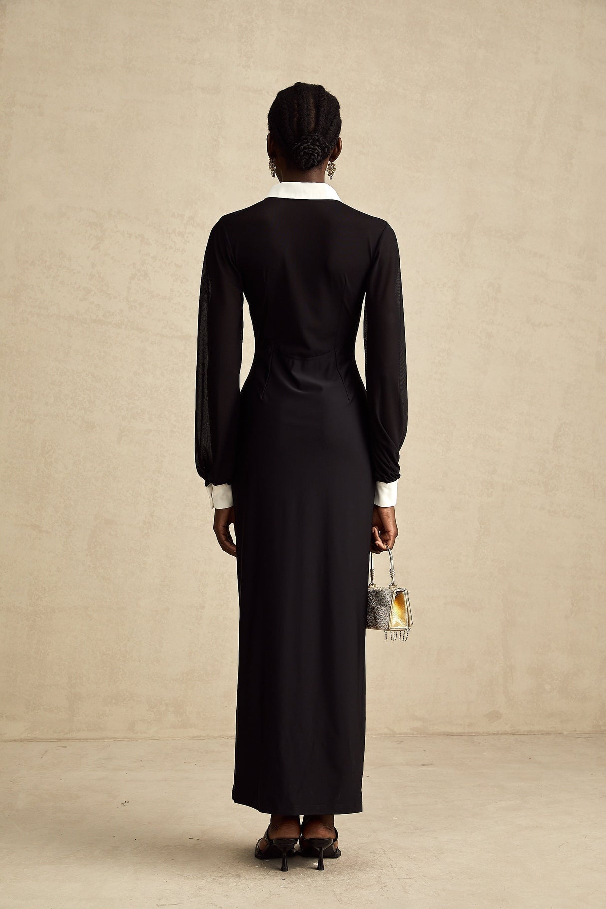 A long flowing maxi dress with contrasting colors and semisheer fabric featuring a delicate and feminine design