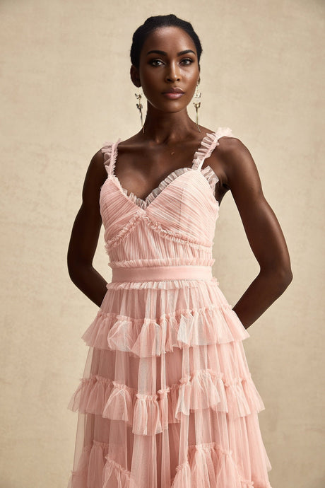 A long flowing maxi dress with layered ruffles made of tulle fabric featuring a delicate and ethereal appearance