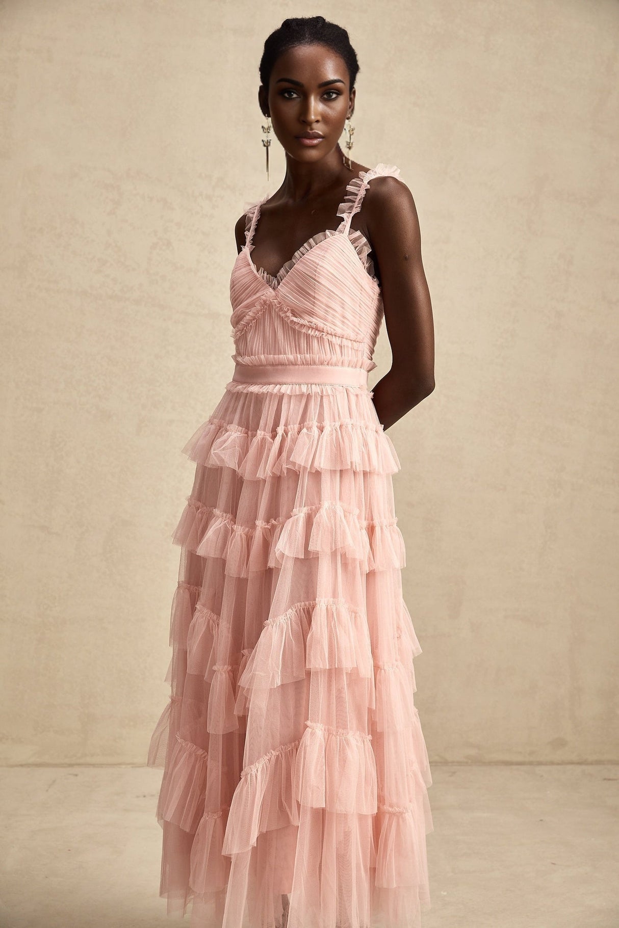 A long flowing maxi dress with layered ruffles made of tulle fabric featuring a romantic and ethereal design