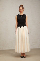 A long flowing maxi dress with puffed sleeves featuring colorblocked sections in contrasting hues named Josette