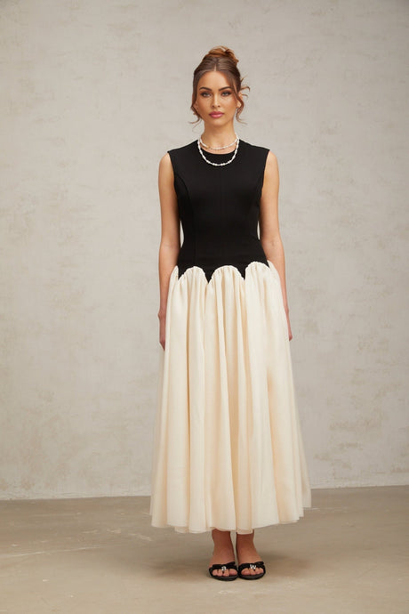 A long flowing maxi dress with puffed sleeves featuring colorblocked sections in contrasting hues named Josette