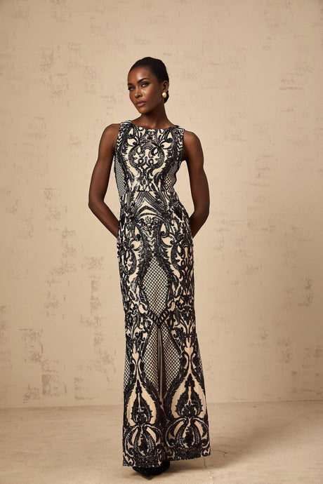 A long flowing maxi dress with sheer mesh fabric adorned with sparkling sequins in a feminine silhouette