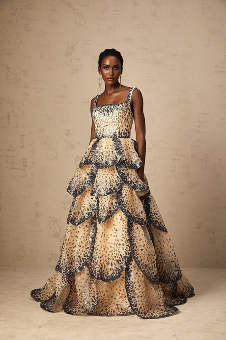 A long flowing maxi dress with tiered layers featuring sequined petal details throughout the fabric creating a shimmering effect