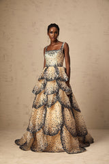 A long flowing maxi dress with tiered layers featuring sequined petal details throughout the fabric creating a shimmering effect