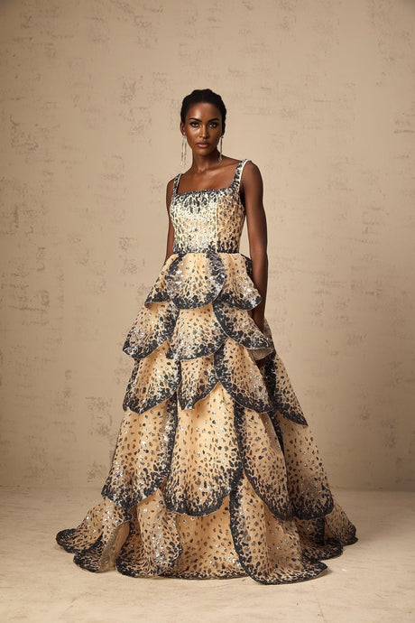 A long flowing maxi dress with tiered layers featuring sequined petal details throughout the fabric creating a shimmering effect