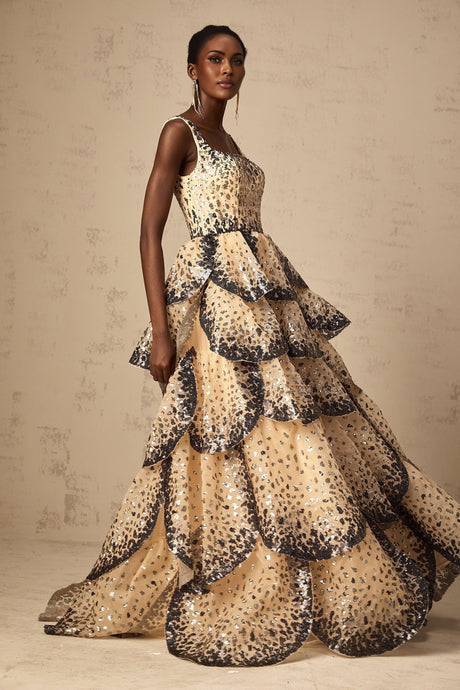 A long flowing maxi dress with tiered layers featuring sequined petal embellishments and a feminine silhouette