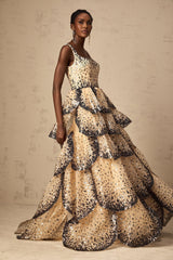 A long flowing maxi dress with tiered layers featuring sequined petal embellishments and a feminine silhouette
