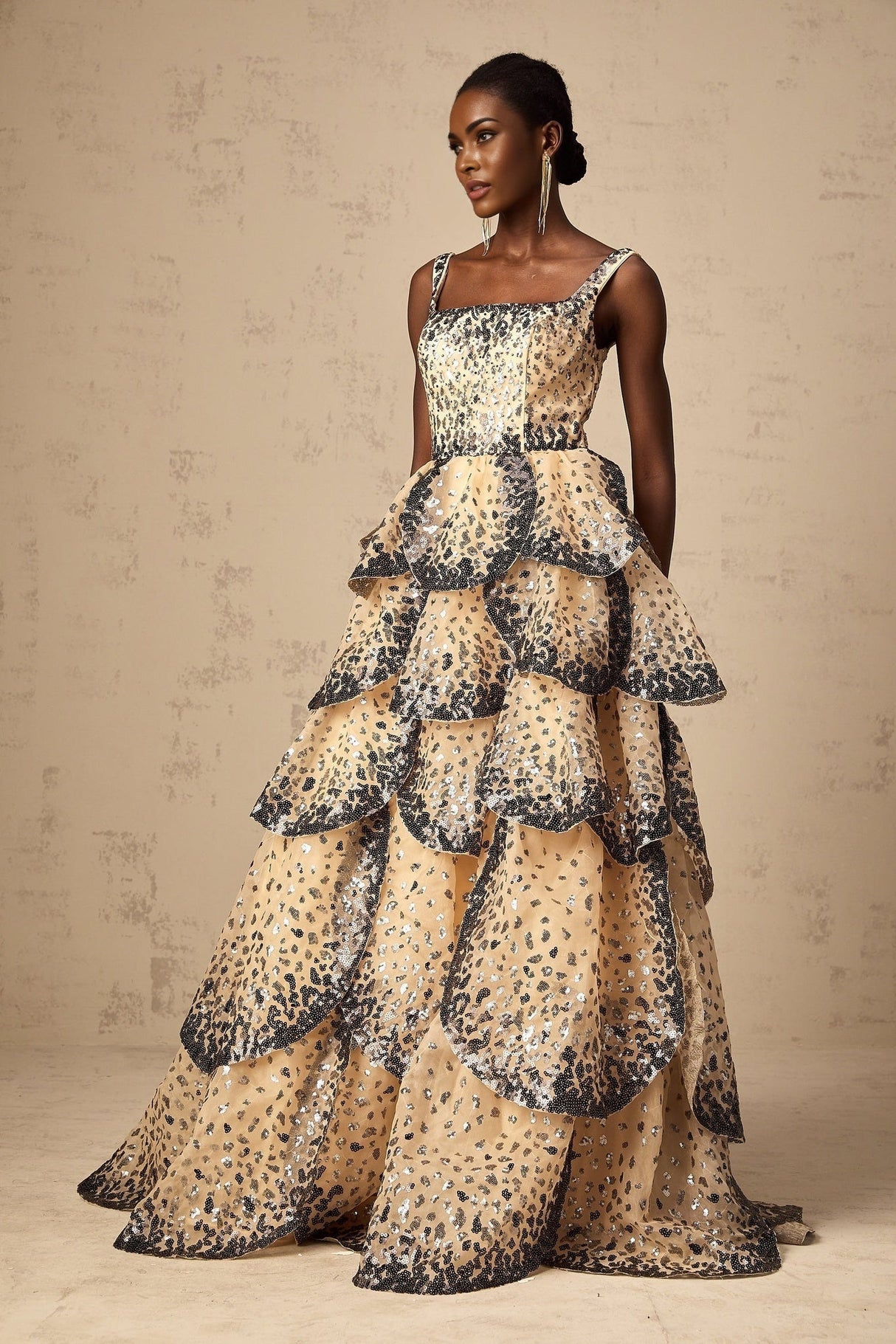 A long flowing maxi dress with tiered layers featuring shimmering sequin embellishments in a petal design