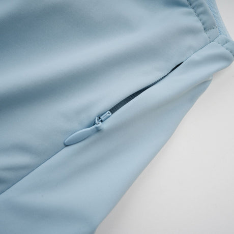 A long flowy baby blue maxi dress with an asymmetric neckline and pleated skirt detail