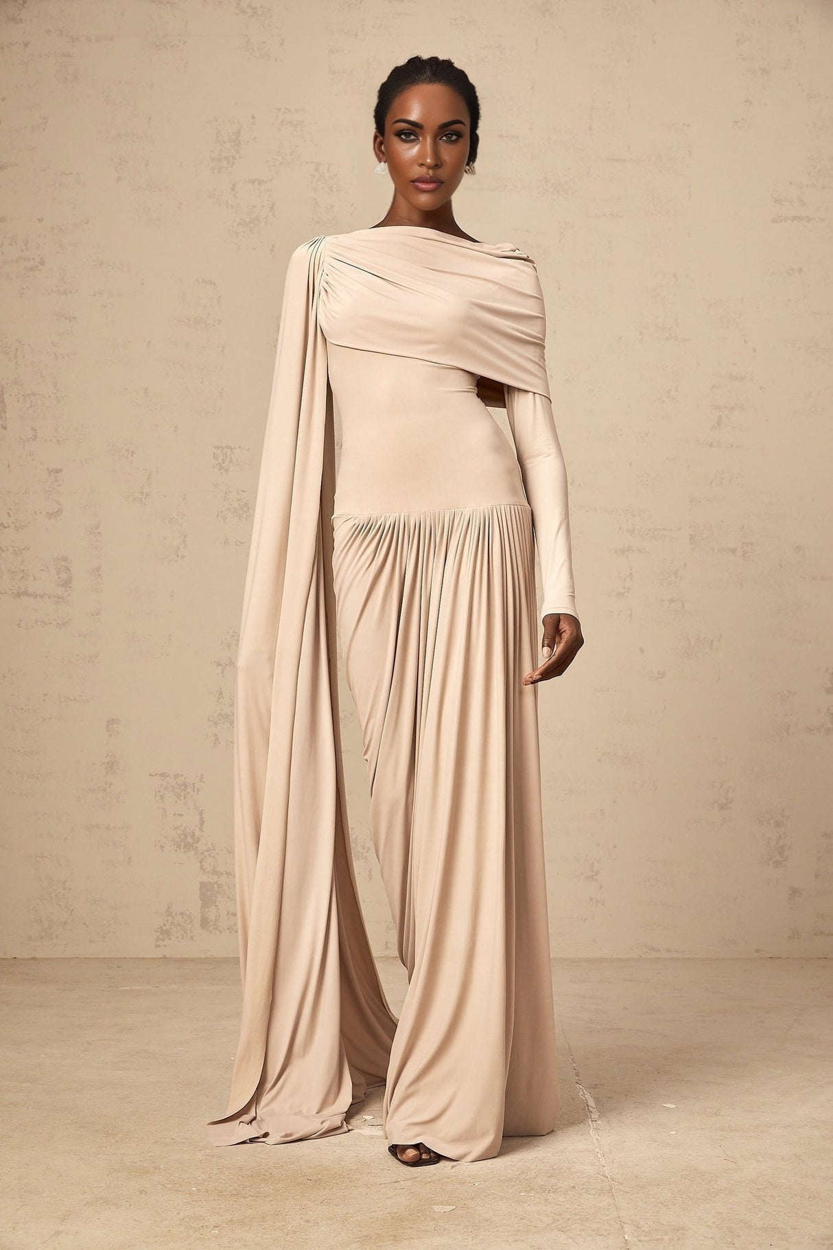 A long flowy maxi dress in neutral tones featuring a unique ribbon design and draped silhouette
