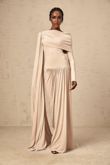A long flowy maxi dress in neutral tones featuring a unique ribbon design and draped silhouette