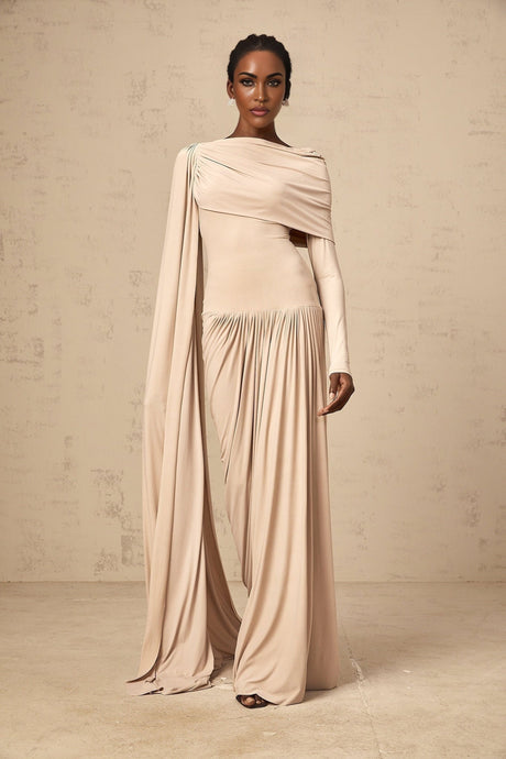 A long flowy maxi dress in neutral tones featuring a unique ribbon design and draped silhouette