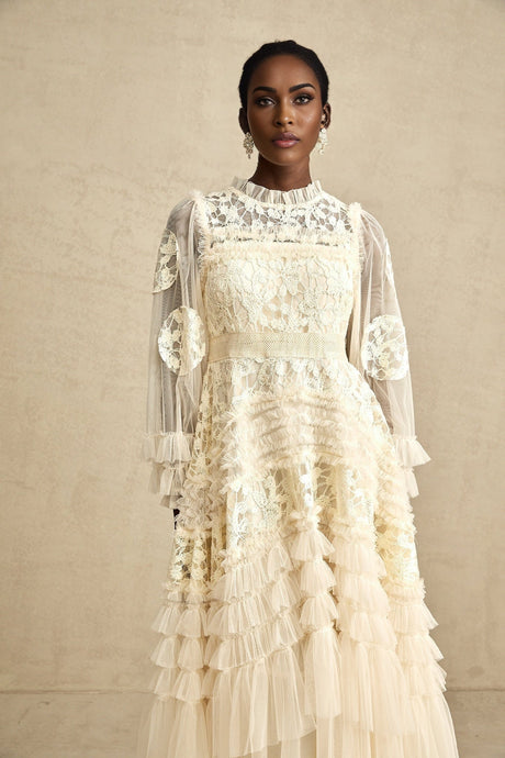 A long flowy maxi dress with layered tulle featuring delicate floral embroidery in a capucine color