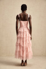 A long flowy maxi dress with multiple layers of ruffled tulle fabric creating a romantic and ethereal look