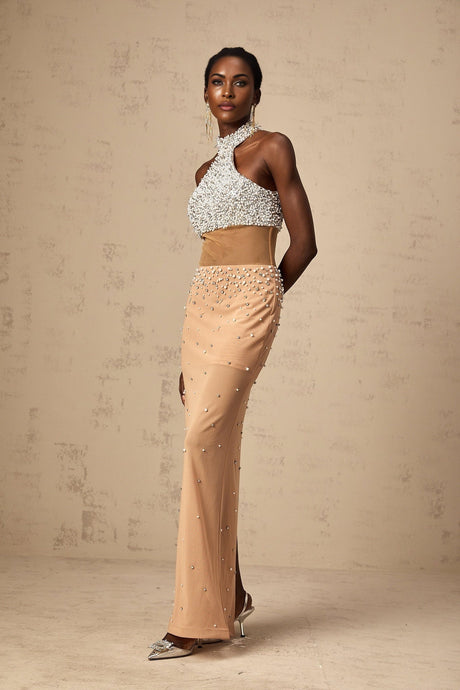 A long flowy maxi dress with sheer fabric adorned with faux pearl embellishments