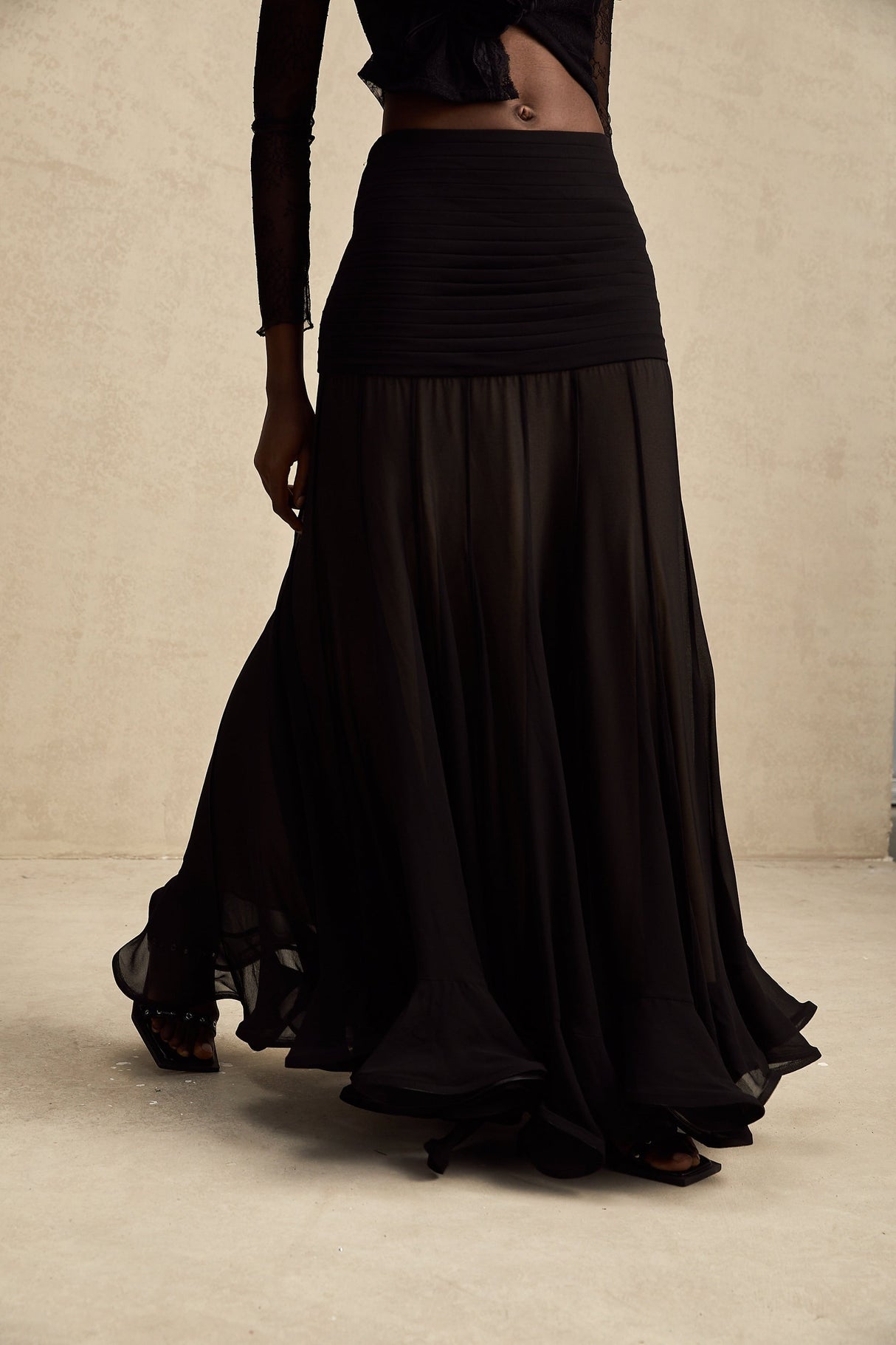 A long flowy maxi skirt in pale colors with ruffles and pleats made of rayon and tulle fabric