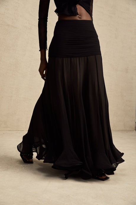 A long flowy maxi skirt in pale colors with ruffles and pleats made of rayon and tulle fabric